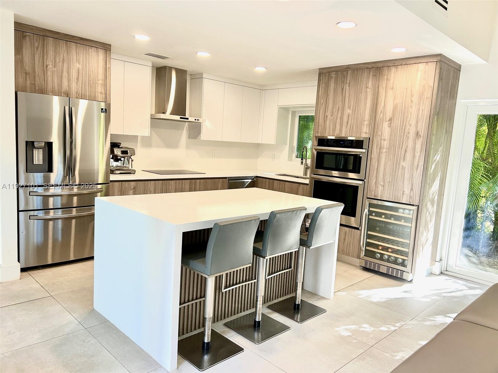 4445 Red Road Coral Gables, FL 33146 - Photo 10 of 41 a kitchen with stainless steel appliances kitchen island granite countertop a refrigerator and a stove top oven