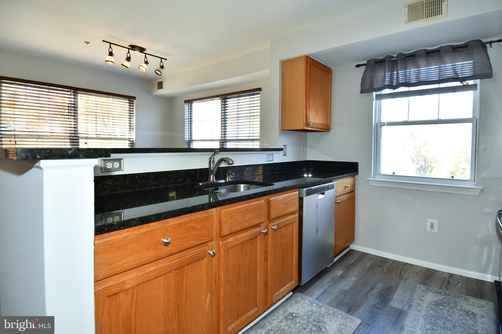 14100 Farnsworth Lane, Unit 2202 Upper Marlboro, MD 20772 - Photo 11 of 38 a kitchen with granite countertop white cabinets sink and window