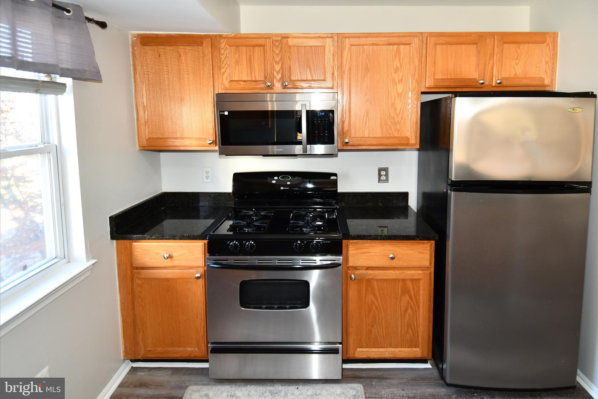 14100 Farnsworth Lane, Unit 2202 Upper Marlboro, MD 20772 - Photo 12 of 38 a kitchen with stainless steel appliances granite countertop a stove and a microwave