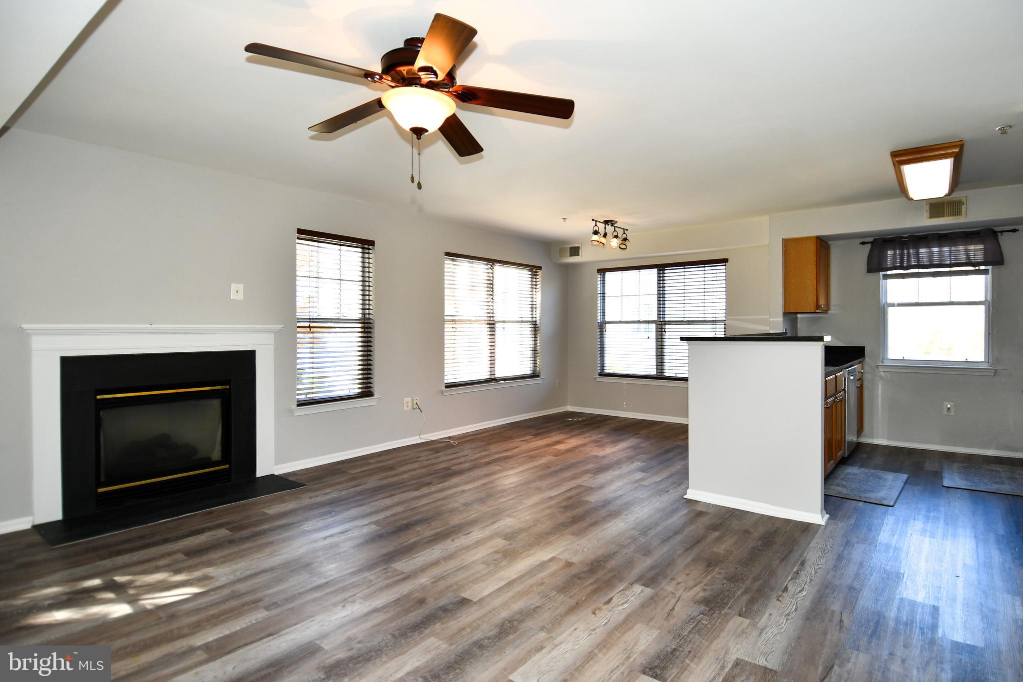 14100 Farnsworth Lane, Unit 2202 Upper Marlboro, MD 20772 - Photo 14 of 38 a view of a kitchen a ceiling fan wooden floor and a fireplace