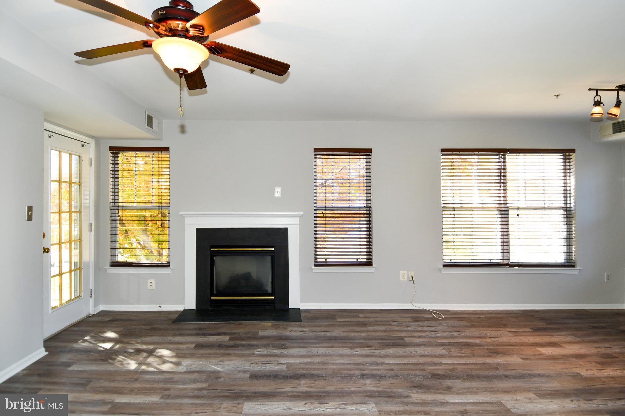 14100 Farnsworth Lane, Unit 2202 Upper Marlboro, MD 20772 - Photo 18 of 38 a view of an empty room with wooden floor fireplace and a window