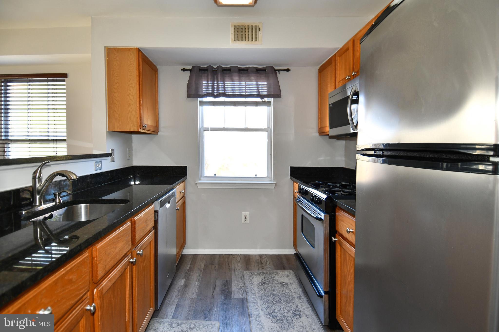 14100 Farnsworth Lane, Unit 2202 Upper Marlboro, MD 20772 - Photo 3 of 38 a kitchen with a sink stove and refrigerator