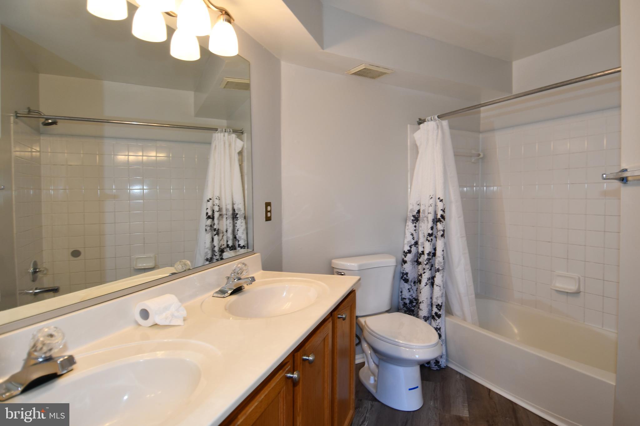 14100 Farnsworth Lane, Unit 2202 Upper Marlboro, MD 20772 - Photo 31 of 38 a bathroom with a sink a toilet and shower