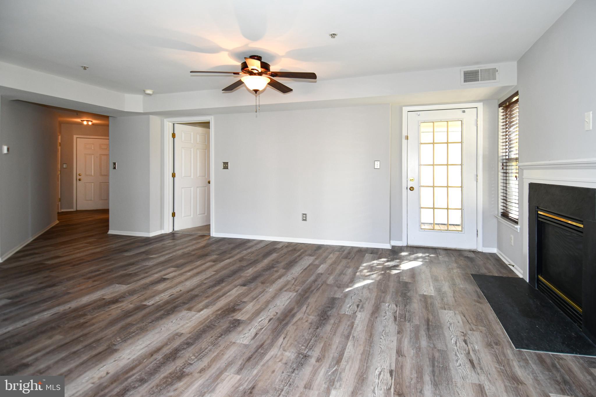 14100 Farnsworth Lane, Unit 2202 Upper Marlboro, MD 20772 - Photo 4 of 38 a view of an empty room with wooden floor and a window