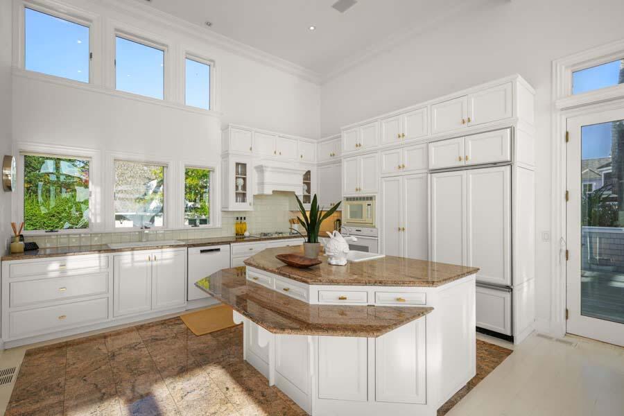 27 Ocean Bluff Drive Mashpee, MA 02649 - Photo 17 of 55 a kitchen with kitchen island granite countertop a stove a sink a refrigerator and white cabinets with wooden floor