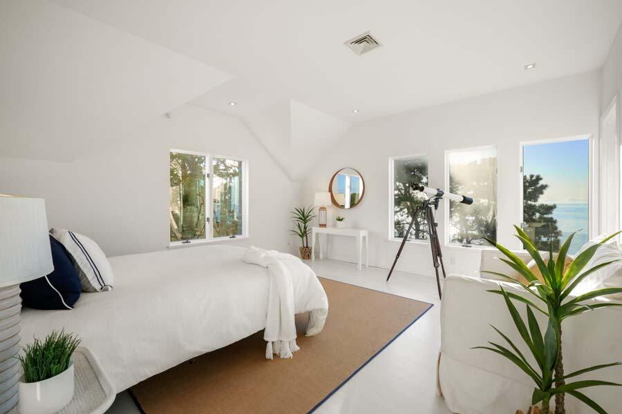 27 Ocean Bluff Drive Mashpee, MA 02649 - Photo 34 of 55 a bedroom with a bed and potted plants next to a large window