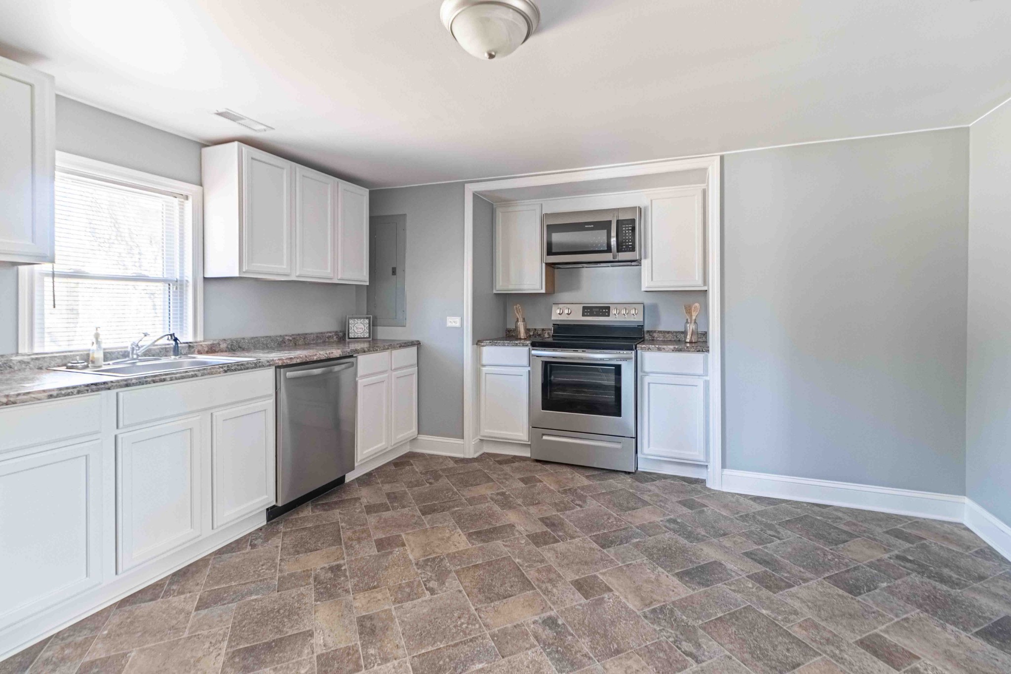 8144 Spot Light Road Lyles, TN 37098 - Photo 11 of 24 a kitchen with granite countertop a stove top oven sink and cabinets
