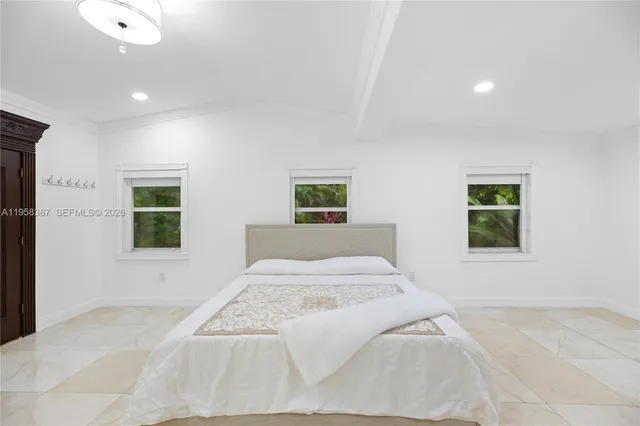 a bedroom with a large bed and a window