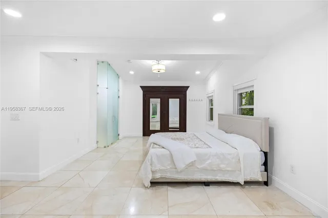 a bedroom with a large bed and painting on the wall