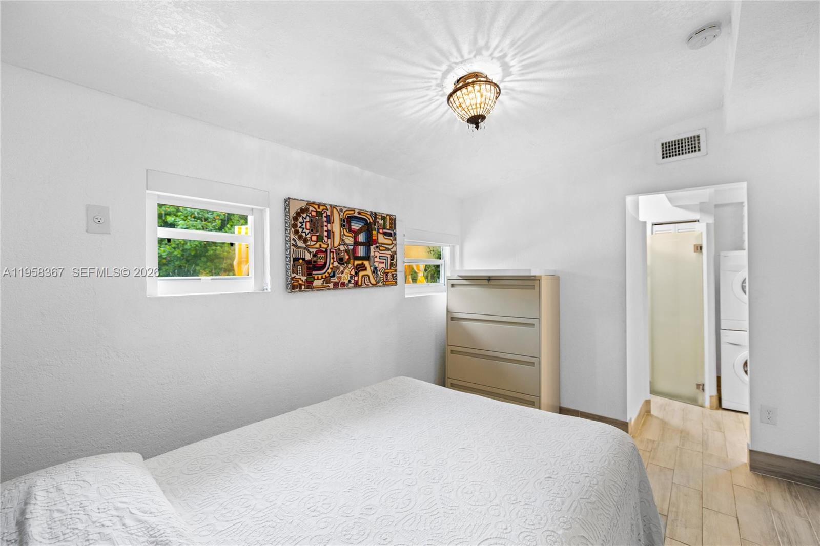 12300 Old Cutler Road, Unit 1 Pinecrest, FL 33156 - Photo 18 of 39 a bedroom with a bed and a chandelier