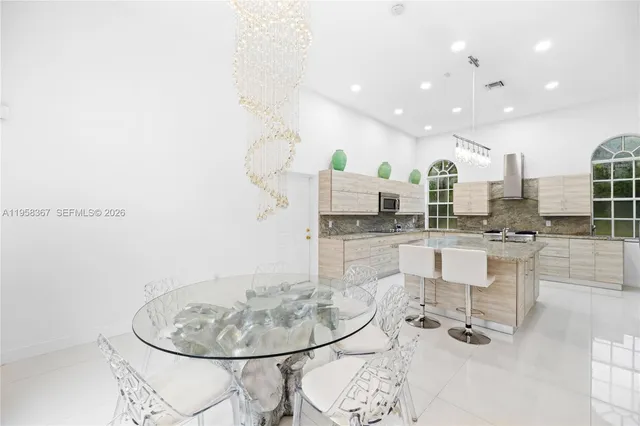 a dining room with kitchen view and a chandelier