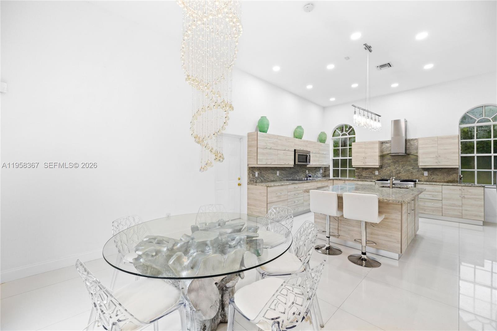 12300 Old Cutler Road, Unit 1 Pinecrest, FL 33156 - Photo 8 of 39 a dining room with kitchen view and a chandelier