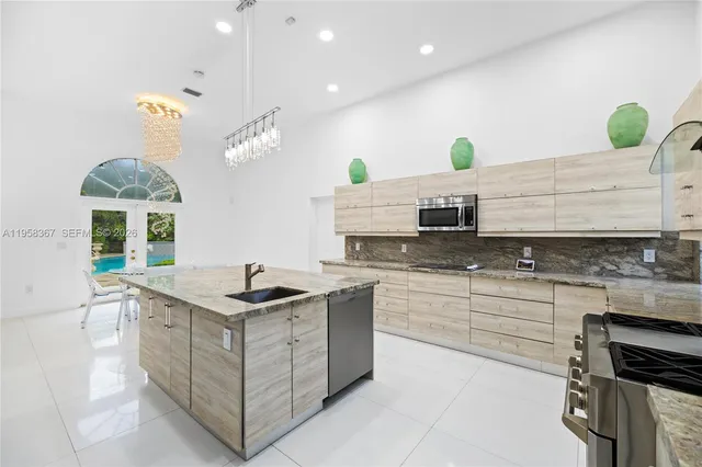 a kitchen with kitchen island granite countertop a sink and a stove