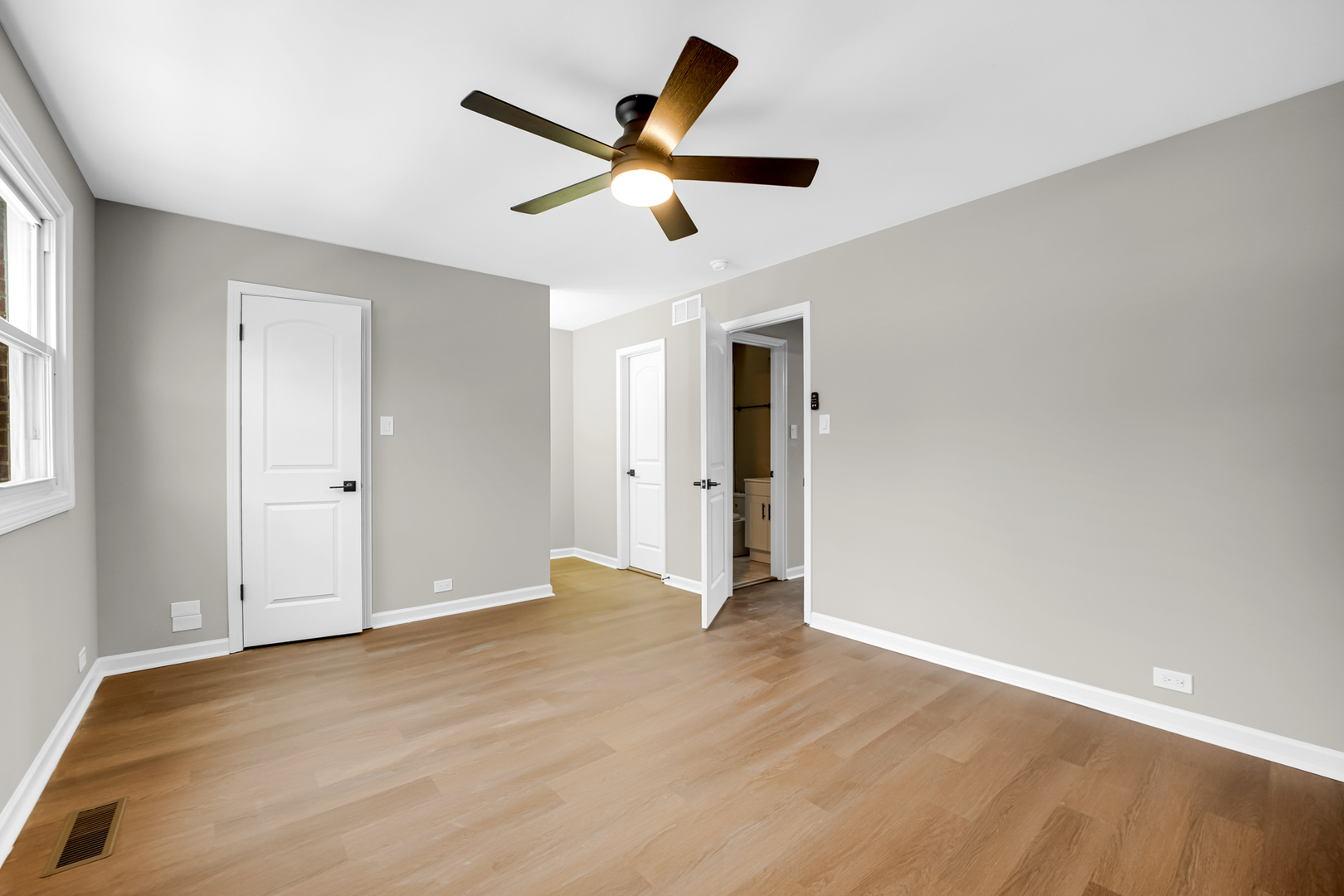1602 West 103rd Street Chicago, IL 60643 - Photo 12 of 22 a view of an empty room with wooden floor and a ceiling fan