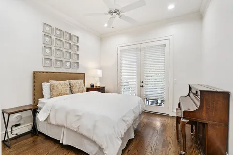 a bedroom with a bed a dresser and wooden floor