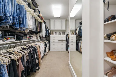 a view of walk in closet with clothes and shoes