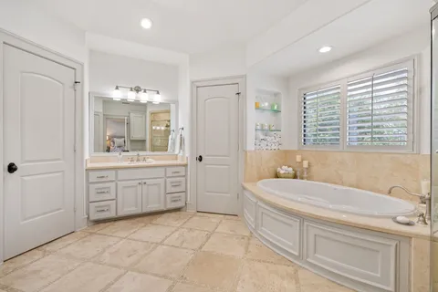 a spacious bathroom with a granite countertop sink a toilet a mirror and a bathtub
