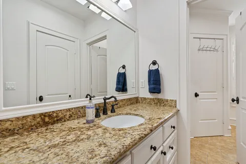 a bathroom with a granite countertop sink and a mirror