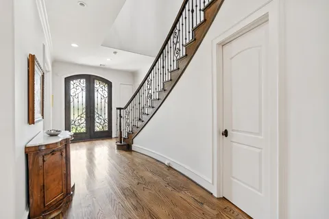 a view of a hallway with wooden floor and staircase
