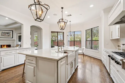 a very nice looking kitchen with granite countertop a stove and a large window