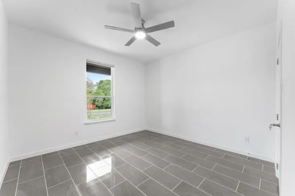 an empty room with a ceiling fan and carpet