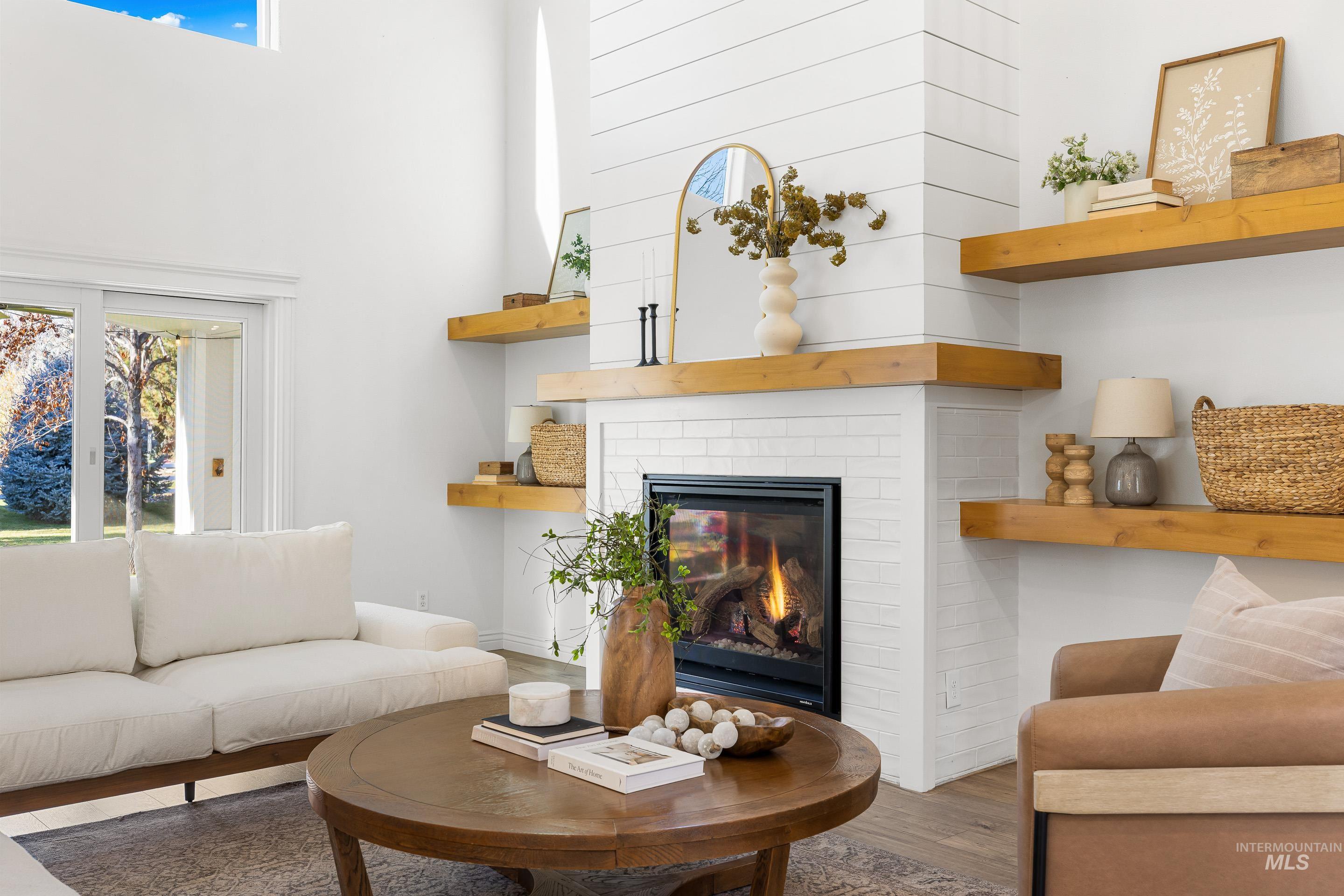1197 North Cove Colony Way Eagle, ID 83616 - Photo 16 of 50 Living area featuring wood finished floors and a brick fireplace