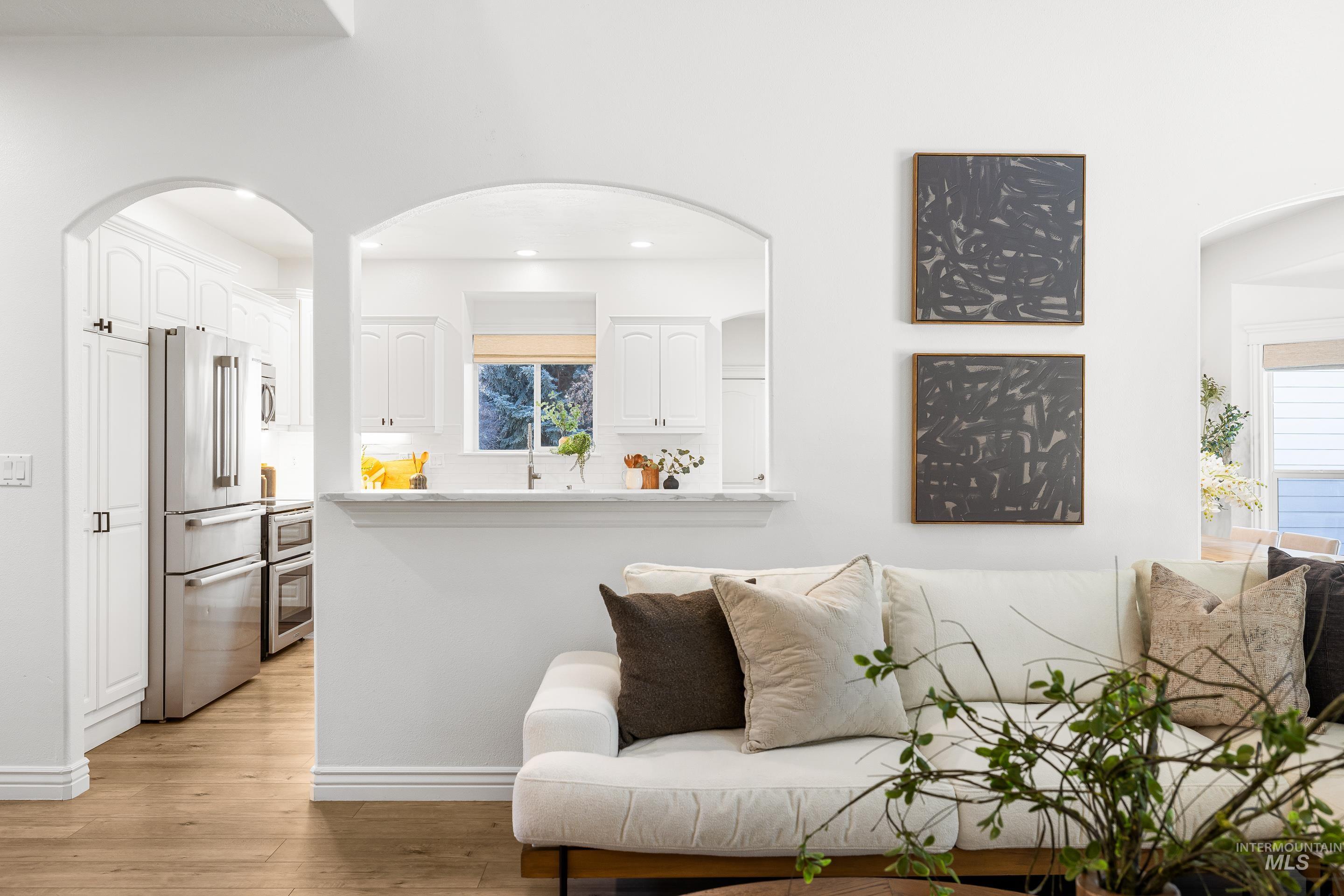 1197 North Cove Colony Way Eagle, ID 83616 - Photo 17 of 50 Living room with arched walkways and light wood-style flooring