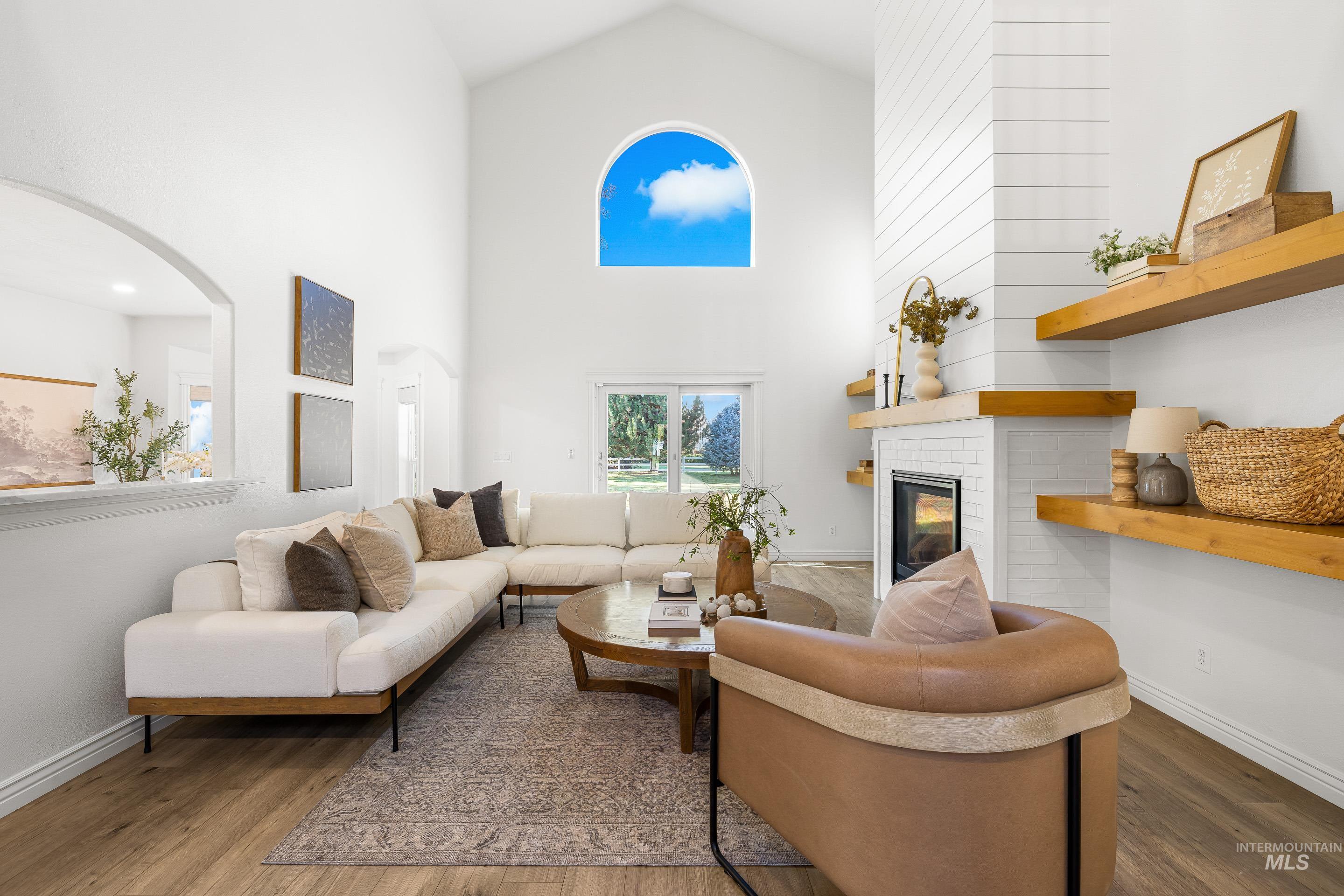 1197 North Cove Colony Way Eagle, ID 83616 - Photo 18 of 50 Living area with high vaulted ceiling, a fireplace, and wood finished floors