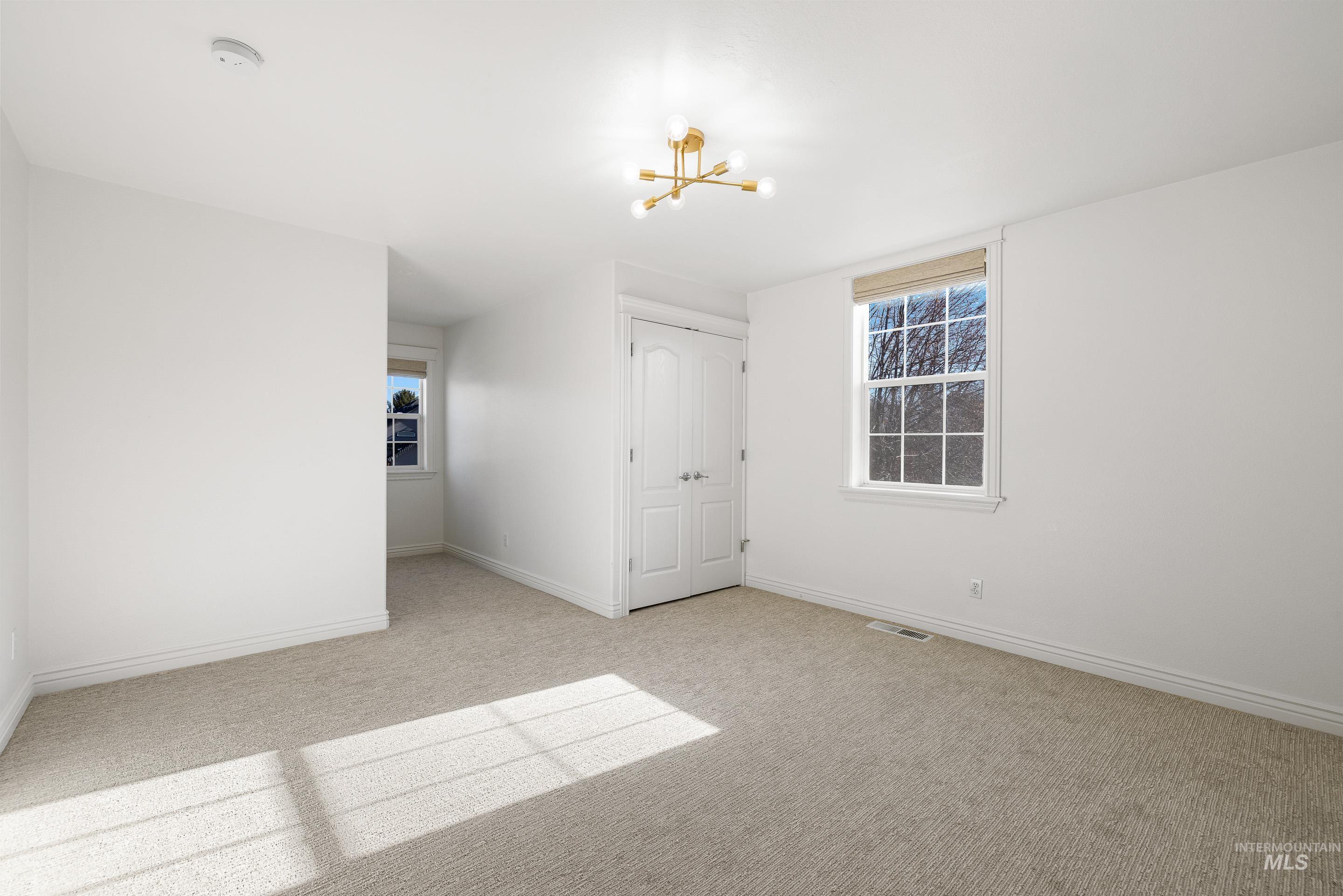 1197 North Cove Colony Way Eagle, ID 83616 - Photo 37 of 50 Empty room with a chandelier and light carpet