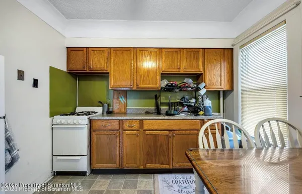 a kitchen with a stove a sink and cabinets