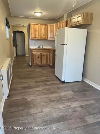 a view of kitchen with wooden floor and electronic appliances