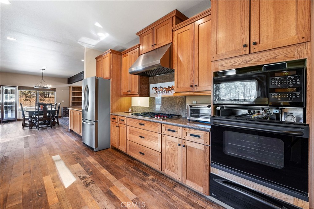 59331 Devils Ladder Road Mountain Center, CA 92561 - Photo 18 of 74 a kitchen with stainless steel appliances a stove a sink cabinets and a wooden floor