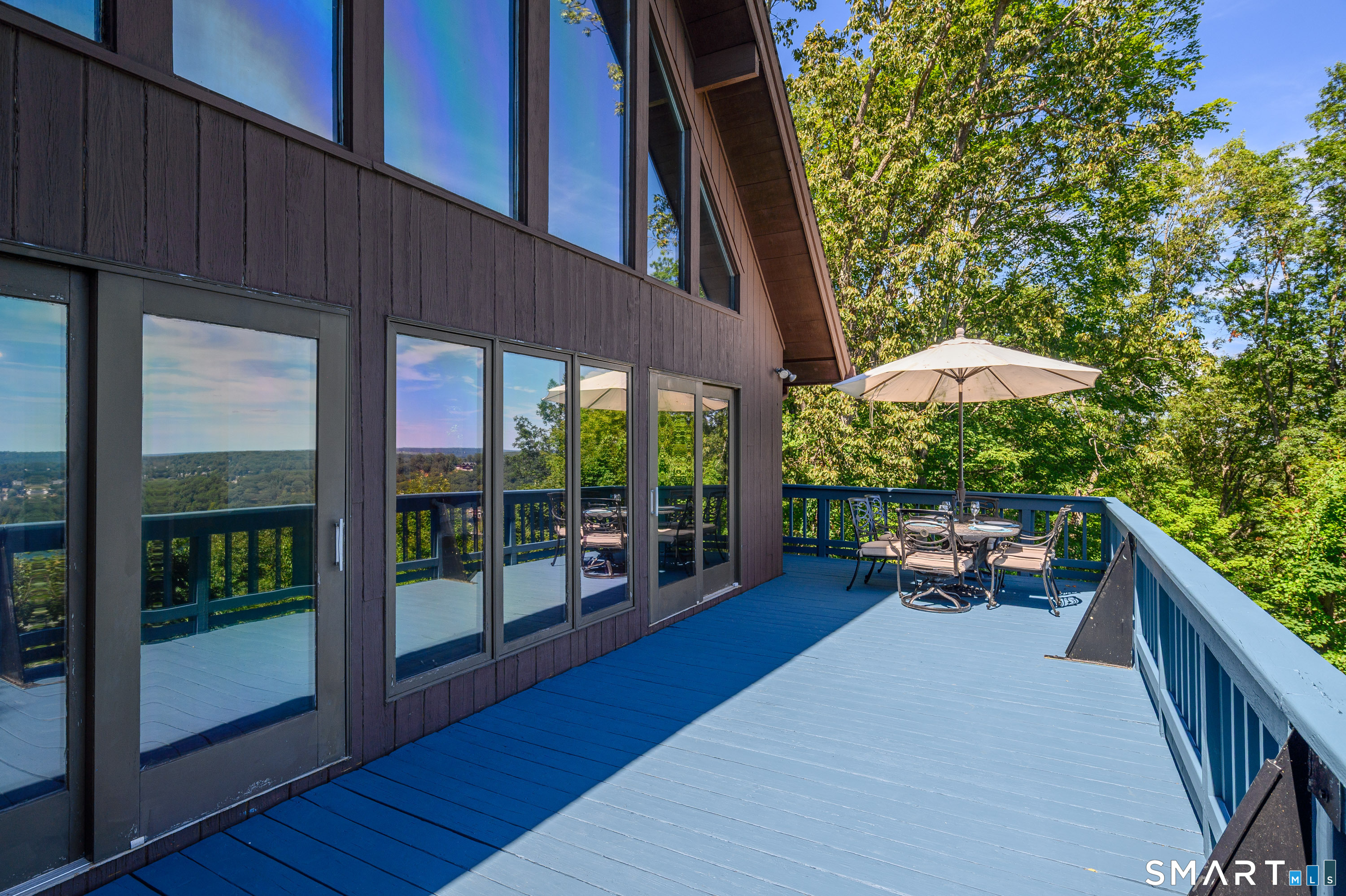 3 Spring Wood Lane New Fairfield, CT 06812 - Photo 16 of 28 a view of a patio with a table and chairs under an umbrella with wooden fence
