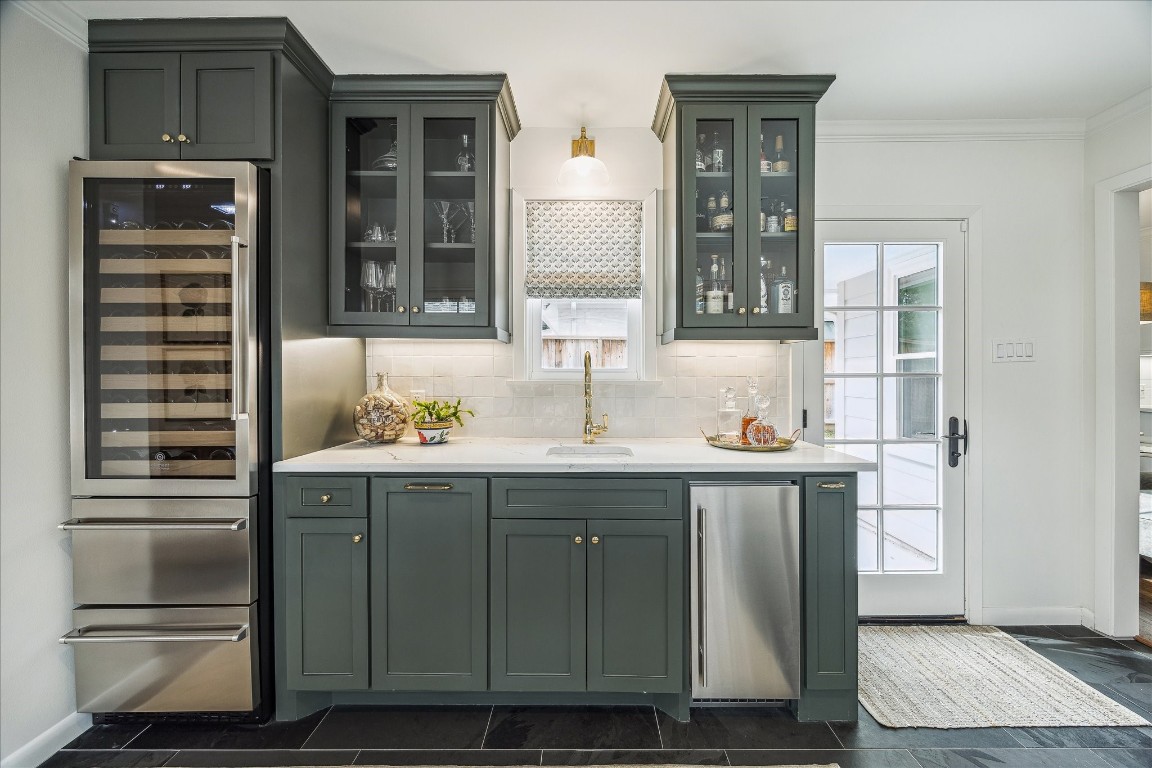 5655 Overbrook Lane Houston, TX 77056 - Photo 20 of 36 This wet bar includes quartz countertops, Scotsman ice machine, an additional sink, and a beverage refrigerator column with beverage drawers below.