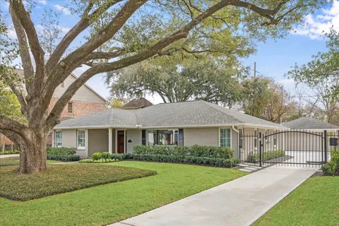 a front view of a house with a garden and trees