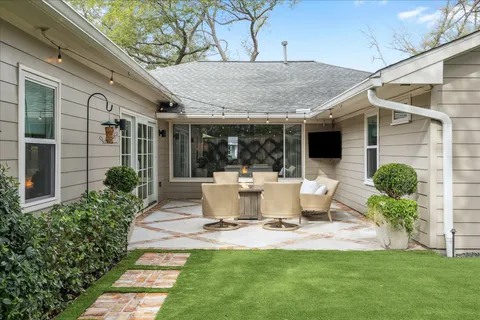 a view of a patio with couches table and chairs with wooden fence and potted plants