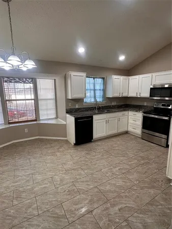 a large kitchen with kitchen island granite countertop a stove sink and microwave