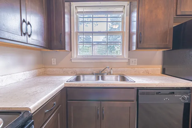 a kitchen with a sink cabinets and window