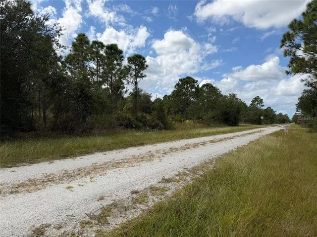 a view of a yard with wooden fence