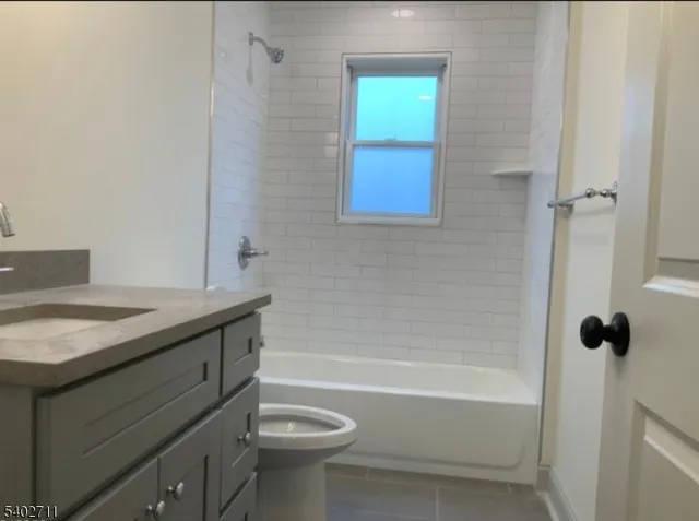 a bathroom with a granite countertop sink a toilet and shower