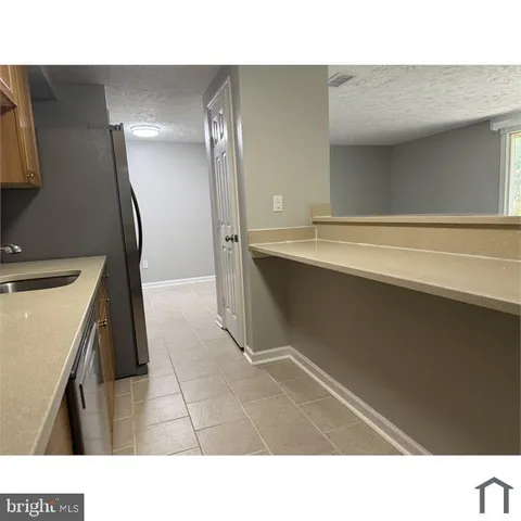 a open kitchen with a sink and refrigerator