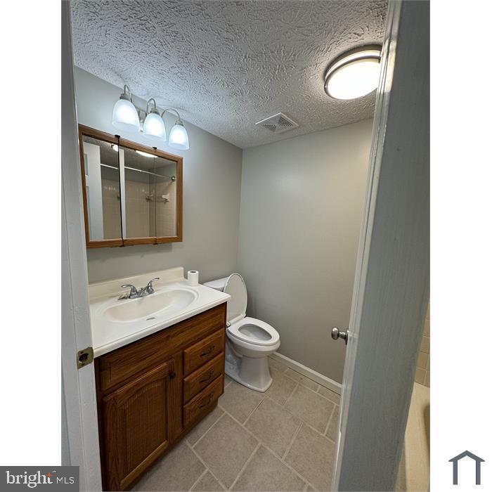 3361 Yost Lane, Unit 103 Dumfries, VA 22026 - Photo 6 of 10 a bathroom with a toilet sink and mirror