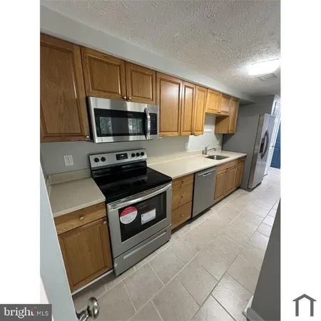 a kitchen with a stove a microwave and cabinets