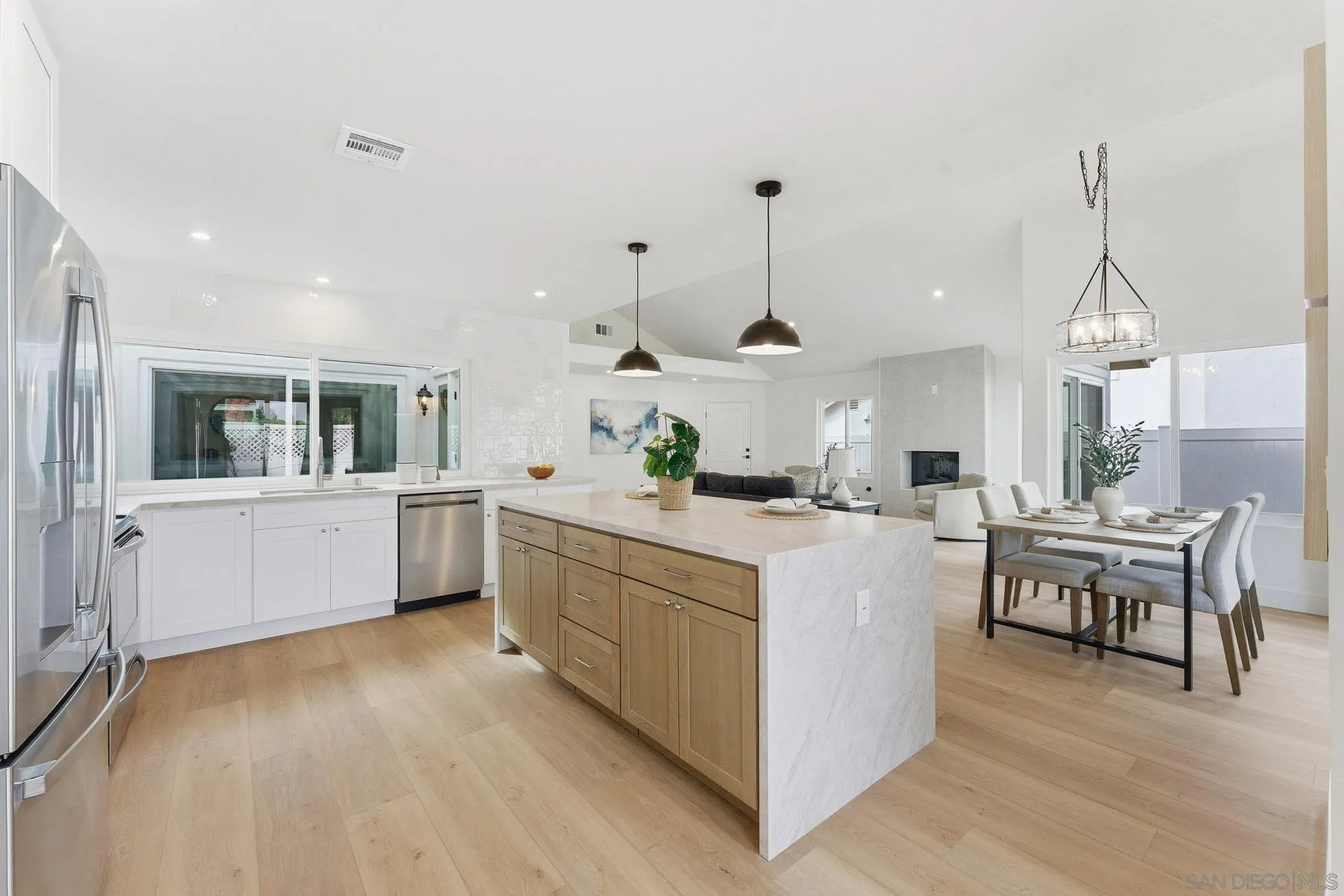 4744 Agora Way Oceanside, CA 92056 - Photo 13 of 31 a kitchen with stainless steel appliances kitchen island wooden floors stove and white cabinets