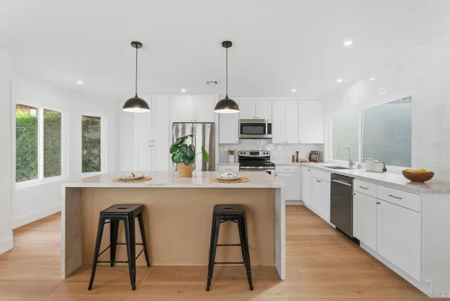 a kitchen with white cabinets and white appliances