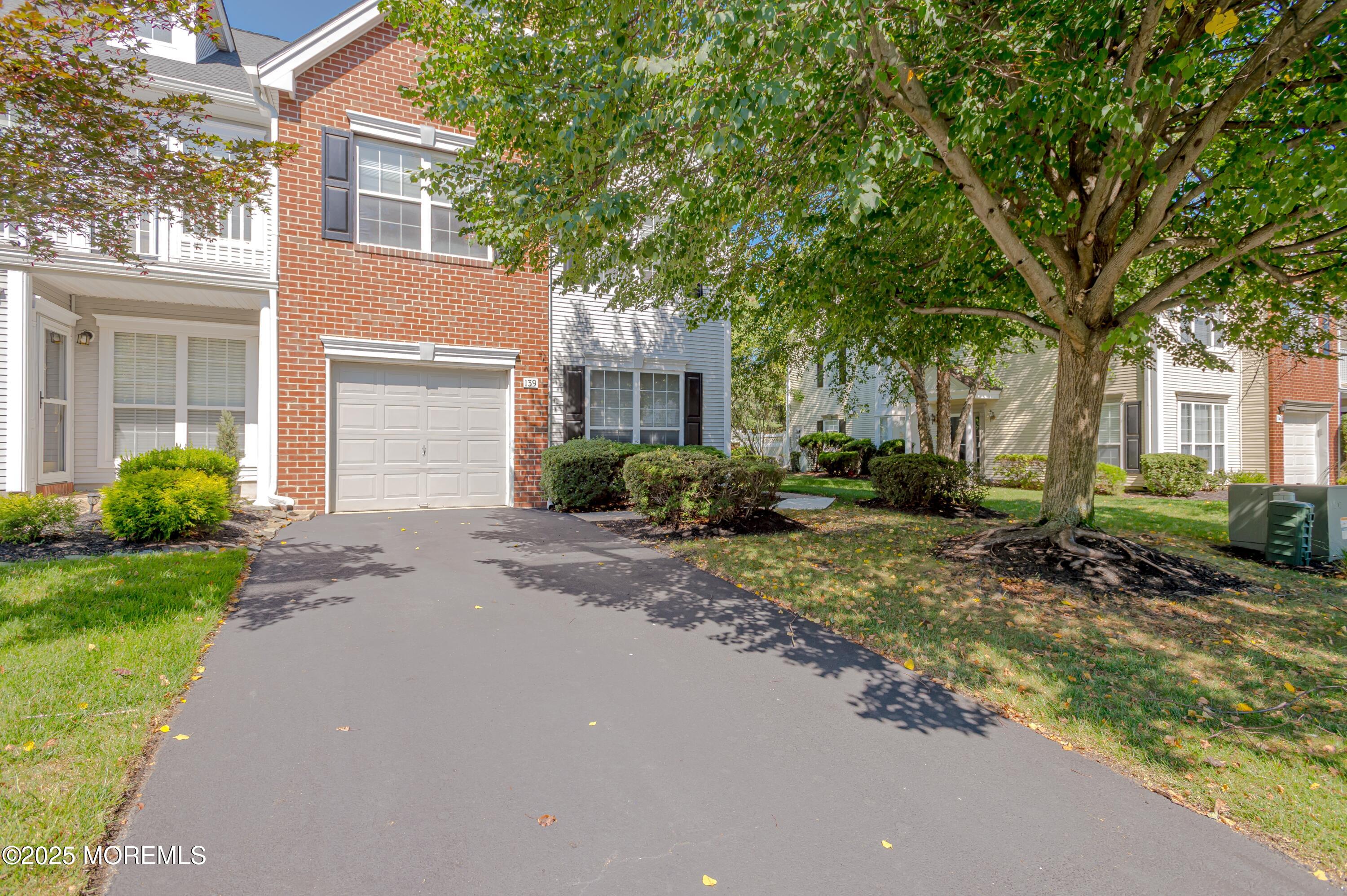 139 Tanya Circle, Unit 5506 Asbury Park, NJ 07712 - Photo 1 of 31 a front view of a house with garden and trees