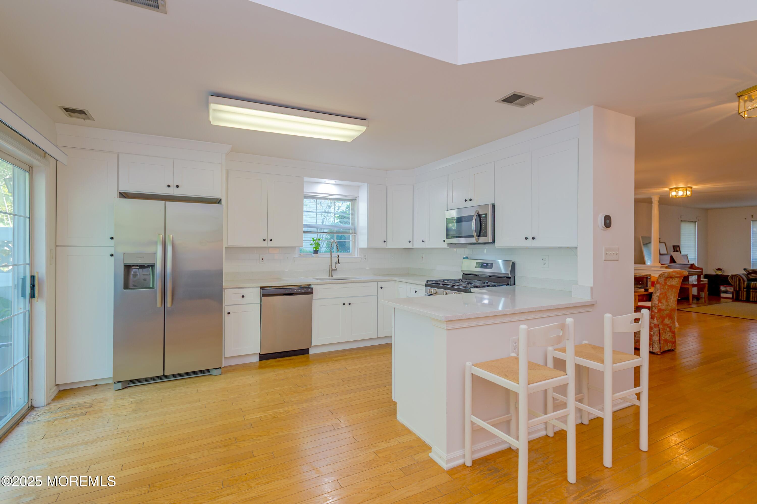 139 Tanya Circle, Unit 5506 Asbury Park, NJ 07712 - Photo 15 of 31 a large kitchen with kitchen island a counter top space cabinets and stainless steel appliances