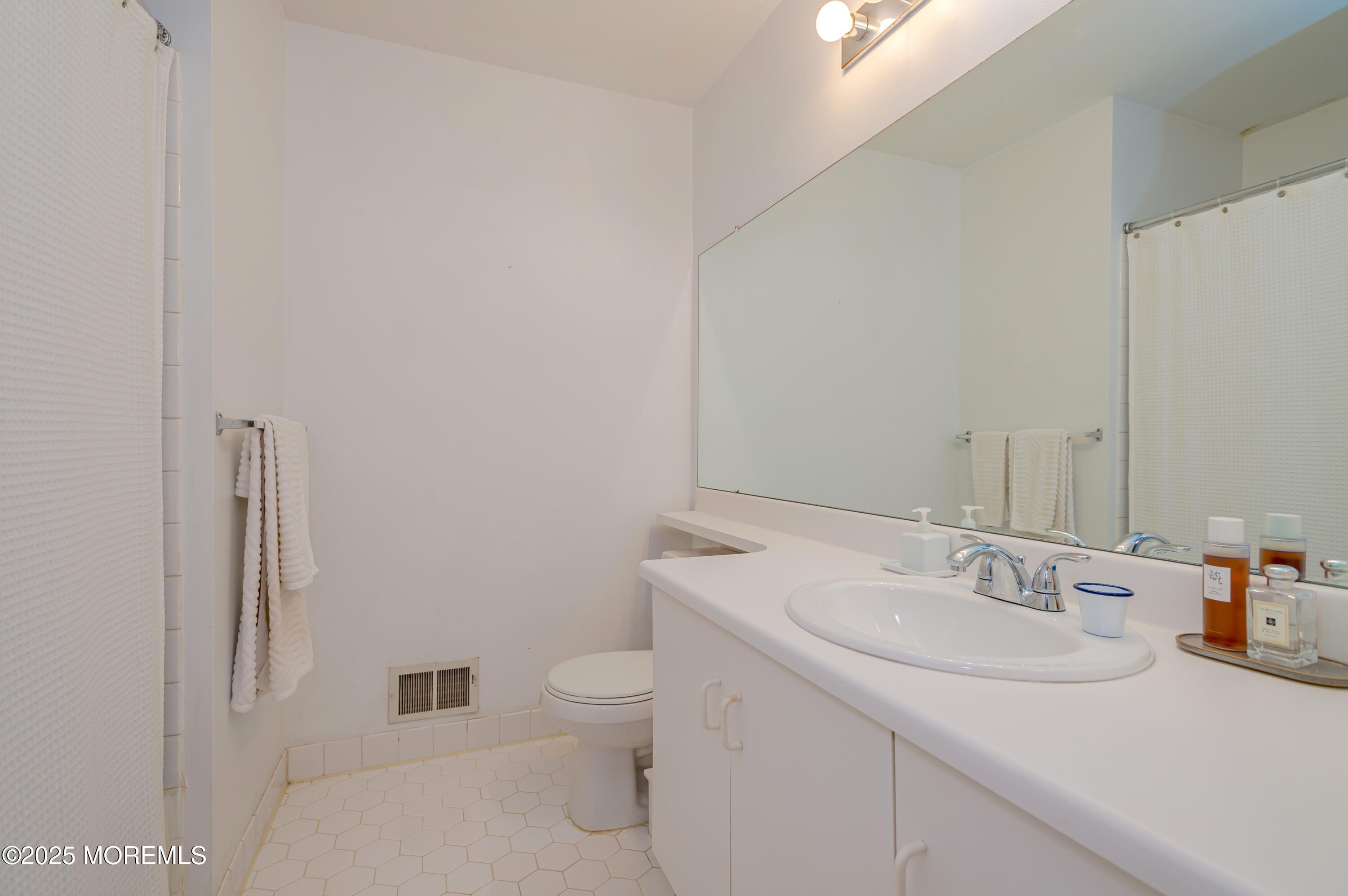 139 Tanya Circle, Unit 5506 Asbury Park, NJ 07712 - Photo 24 of 31 a bathroom with a sink toilet and vanity
