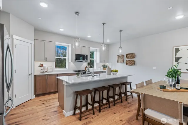 a kitchen with kitchen island a dining table and chairs
