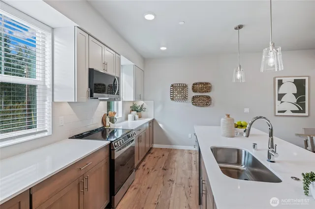 a kitchen with a sink stove and microwave